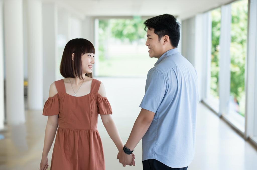 A young couple in Singapore holding hands and smiling, depicting renewed intimacy and connection.